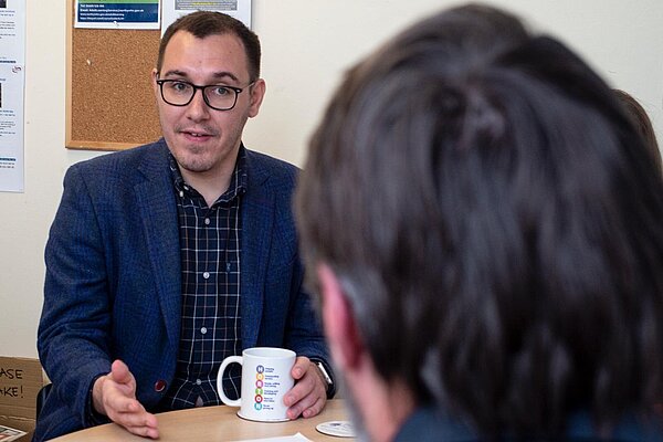 Tom Gordon sat talking a a table whilst at Harrogate Stay Well 