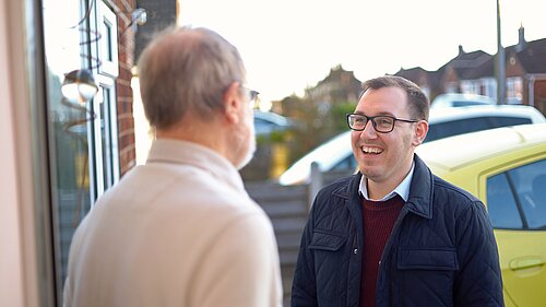 Tom Gordon stood on a doorstep talking to a local resident