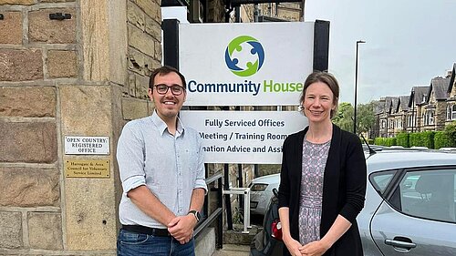 Tom Gordon and the CEO of HADCA in front of Harrogate Community House sign