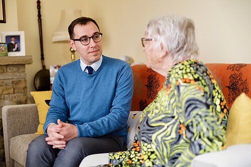 Tom Gordon sat on a sofa with a pensioner