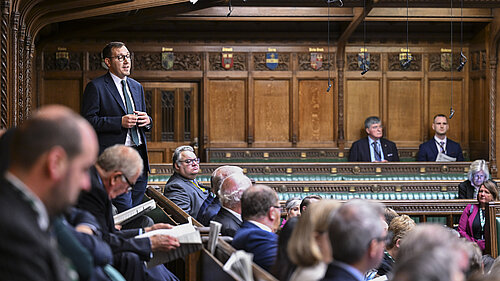 Tom Gordon stood speaking in the House of Commons Chamber