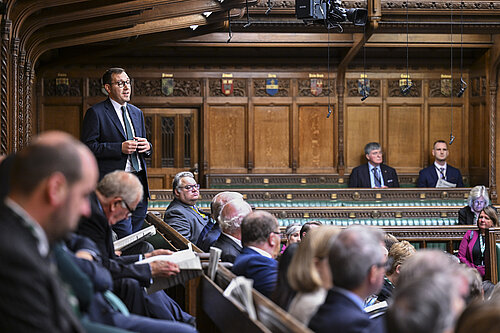 Tom Gordon stood speaking in the House of Commons Chamber